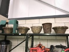 A shelf of miscellaneous including wicker baskets and a garden seat