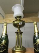 A brass oil lamp on 4 reeded columns with later shade.