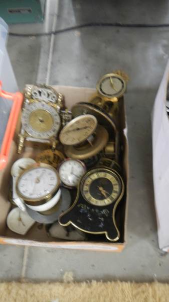 A box of small clocks and movements.