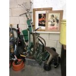 A large quantity of garden tools including rakes etc