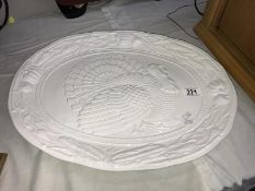 An ornate white platter decorated with a turkey & vegetables