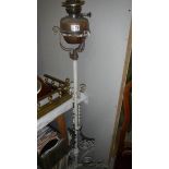 A wrought iron standard oil lamp with brass font.
