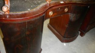 A 19th century mahogany serpentine front desk with single drawer and 2 cupboards.