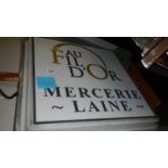 A large French illuminating shop sign, double sided.