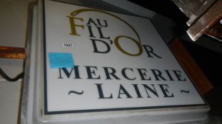 A large French illuminating shop sign, double sided.