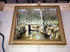 An oil painting of woodland scene with bridge over river signed N.