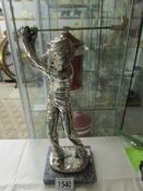 A signed metal figure of a golfer.