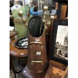 A copper coal scuttle and a brass companion set
