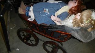 A Victorian style dolls pram and 2 porcelain dolls.