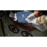 A Victorian style dolls pram and 2 porcelain dolls.