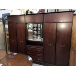 A dark brown bedroom suite including 2 wardrobes and a central dressing section