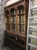 A dark wood stained dresser with multiple bevel edged mirror back