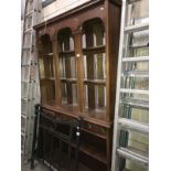 A dark wood stained dresser with multiple bevel edged mirror back