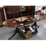 An inlaid oval extending dining table on 2 tripod legs