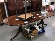 An inlaid oval extending dining table on 2 tripod legs