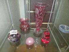 2 cranberry glass vases and 3 paperweights.