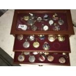 A 3 drawer watch cabinet containing 38 reproduction pocket watches.