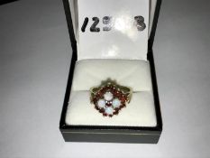 An opal and garnet ring hallmarked 9ct gold 1977, opals ETCW 0.80ct . Ring size R, total weight 4.