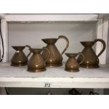 A set of 5 copper graduated jugs