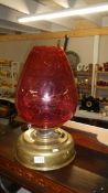 A large brass Sherwood's round wick oil lamp with ruby glass shade.