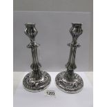 A pair of white metal candlesticks.