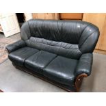 A wood framed green leather 3 seater sofa