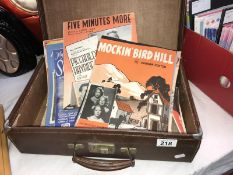 A vintage suitcase containing 1950's sheet music