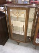 A glazed display cabinet with painted floral leaf decoration