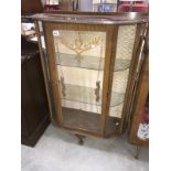 A glazed display cabinet with painted floral leaf decoration