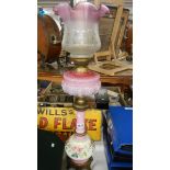 A Victorian oil lamp with pink font and column.