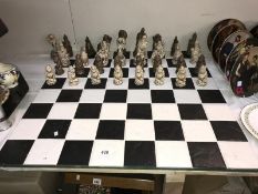 A black & white tiled chess board with Dungeon & Dragon style figure chess pieces