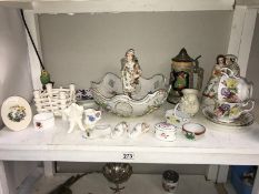 A shelf of porcelain ornaments, bowls, cups & vases etc.