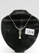 An art deco marcasite necklace set in silver with pearl drop attached.