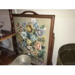 A dark wood stained fire screen with glazed tapestry panel