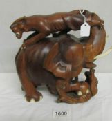 A carved wood elephant being attacked by tigers.