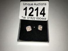 A pair of white gold square shaped diamond earrings.