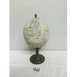 A 20th century decorated ostrich egg on lead base decorated with seascape.