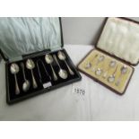 A cased set of silver spoons with sugar tongs and another cased set of silver spoons.