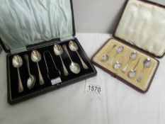A cased set of silver spoons with sugar tongs and another cased set of silver spoons.