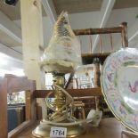 A brass table lamp with carved cameo shell shade.