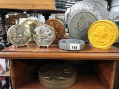 A quantity of coin shaped money boxes