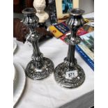 A pair of white metal candlesticks