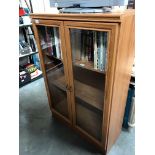 A glazed front bookcase with internal light
