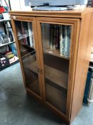 A glazed front bookcase with internal light