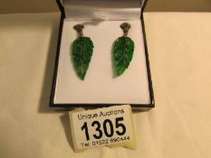 A pair of drop earrings set with jade in the form of leaves and emeralds and diamonds,.