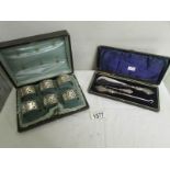 A cased set of 6 silver napkin rings and a cased shoehorn and button hook set.