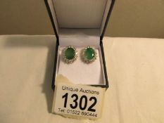 A large pair of 18ct gold emerald and diamond cluster stud earrings. Total emerald carat weight 5.