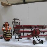 A hanging Red Baron wooden model, a hanging flying trapeze clown and a replica dolls pushchair.