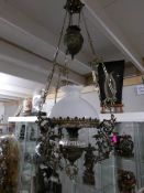 A hanging oil lamp with glass shade.