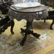 A heavily carved oriental table.